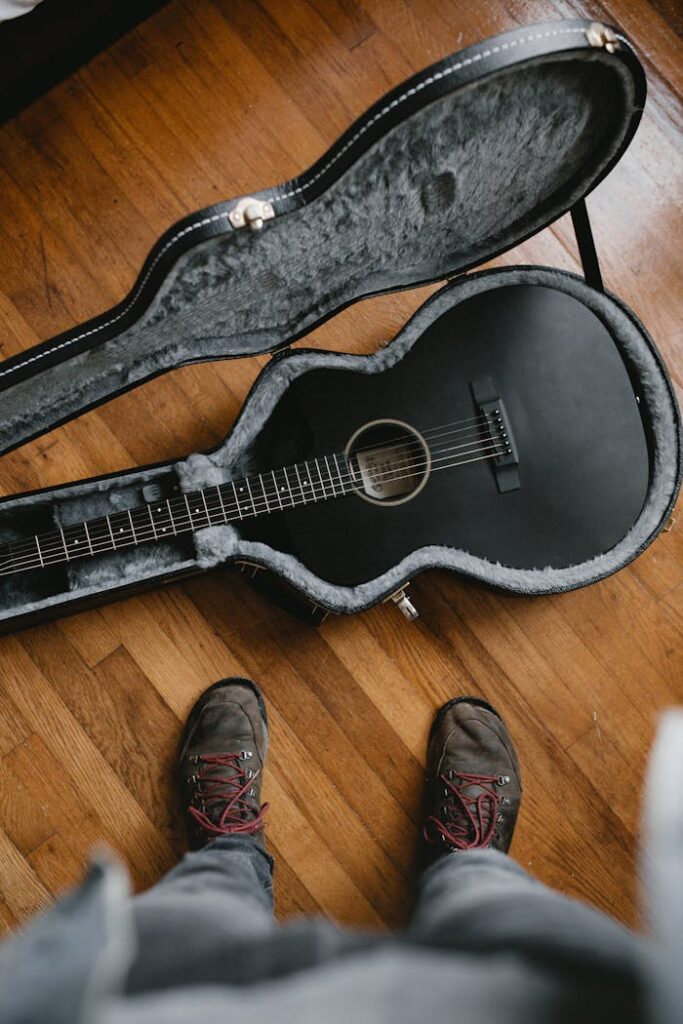 Brown Acoustic Guitar on Black Guitar Stand